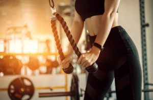 Vitamin C auch für Sportler wichtig, dargestellt von Frau am Trizepsdrücken