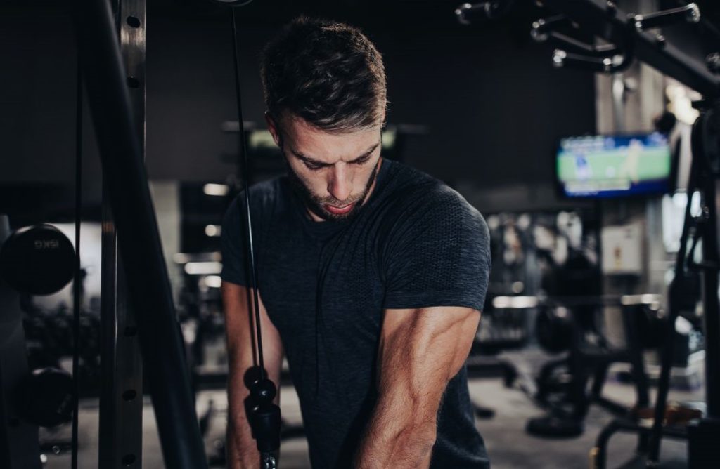 Mann trainiert Trizeps und ist unter Muskelspannung