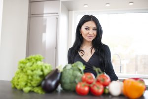 Fitness Model Oxana beim Kochen mit Gemüse, Fitnessernährung