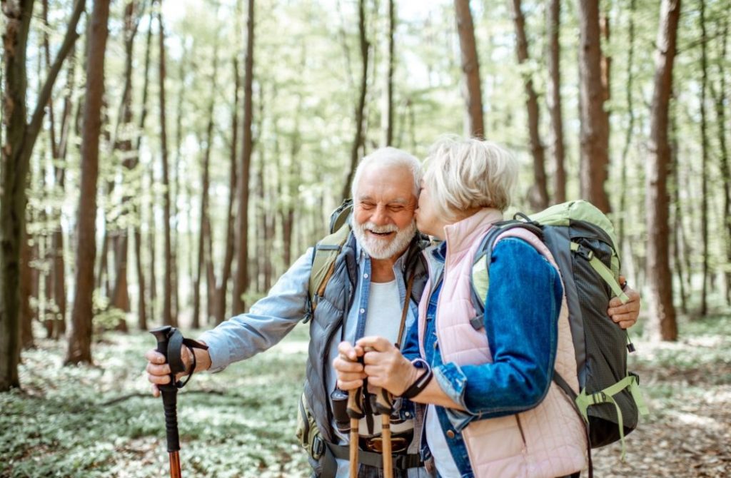 altes Ehepaar wandert im Wald und tankt Vitamin D