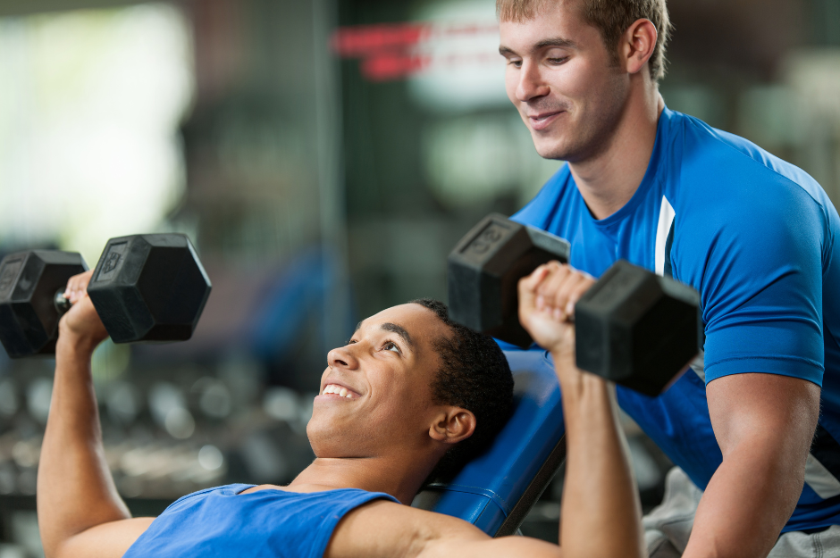 Fitnessstudio mit Betreuung dargestellt von Trainer beim Coaching eines Mitglieds