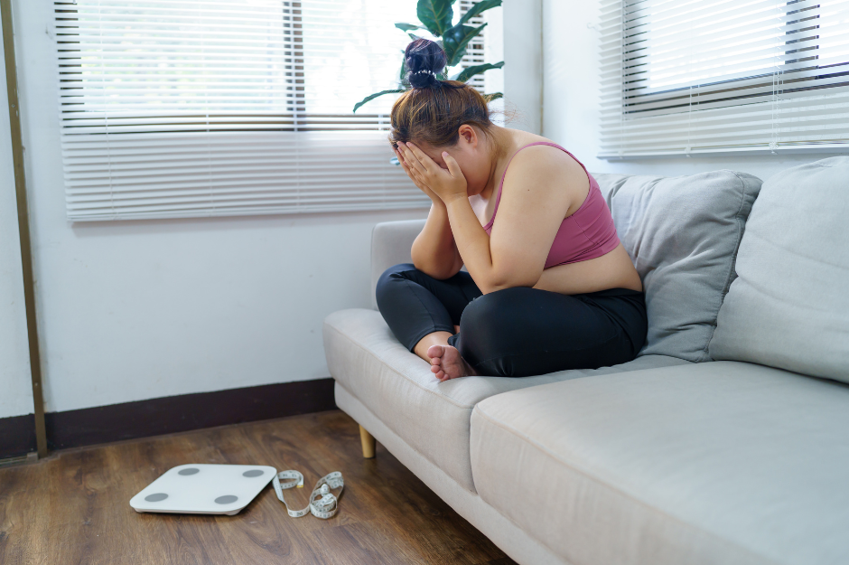 frustrierte Frau im Wohnzimmer fragt sich: kann ich mit Wand-Pilates abnehmen?