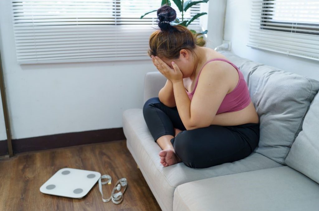der beste Weg zum Abnehmen hat auch Rückschläge, symbolisiert durch frustrierte Frau auf Couch