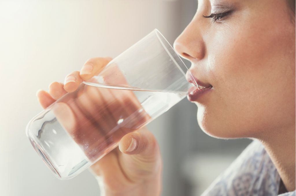 Hunger reduzieren durch Glas Wasser symbolisiert Frau mit Glas