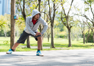 Jogger dehnt sich als Vorbeugung vor Patellasehnen Schmerzen