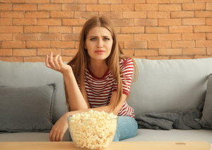 Was tun gegen emotionales Essen, symbolisiert von Frau mit Popcorn