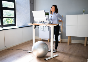 Abnehmen durch Fidgeting symbolisiert von Frau stehend im Home Office