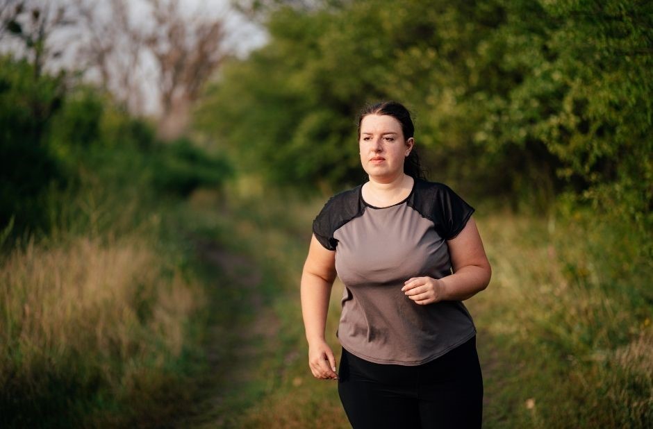 Verhindern Hormone das Abnehmen dargestellt von dicker Frau beim Joggen in der Natur