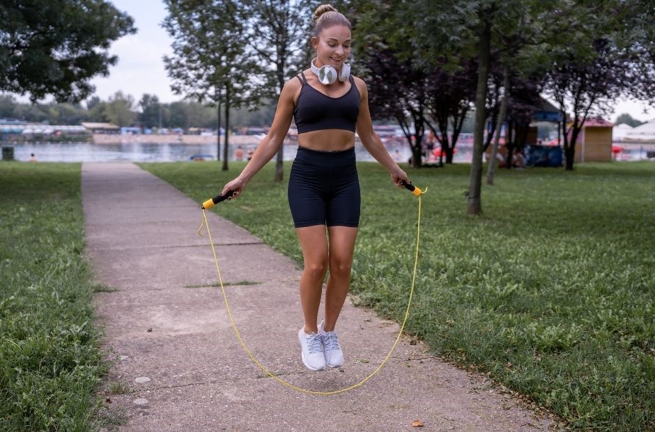 Seilspringen ideal für Bauch Beine Po dargestellt von sportlicher Frau Outdoor