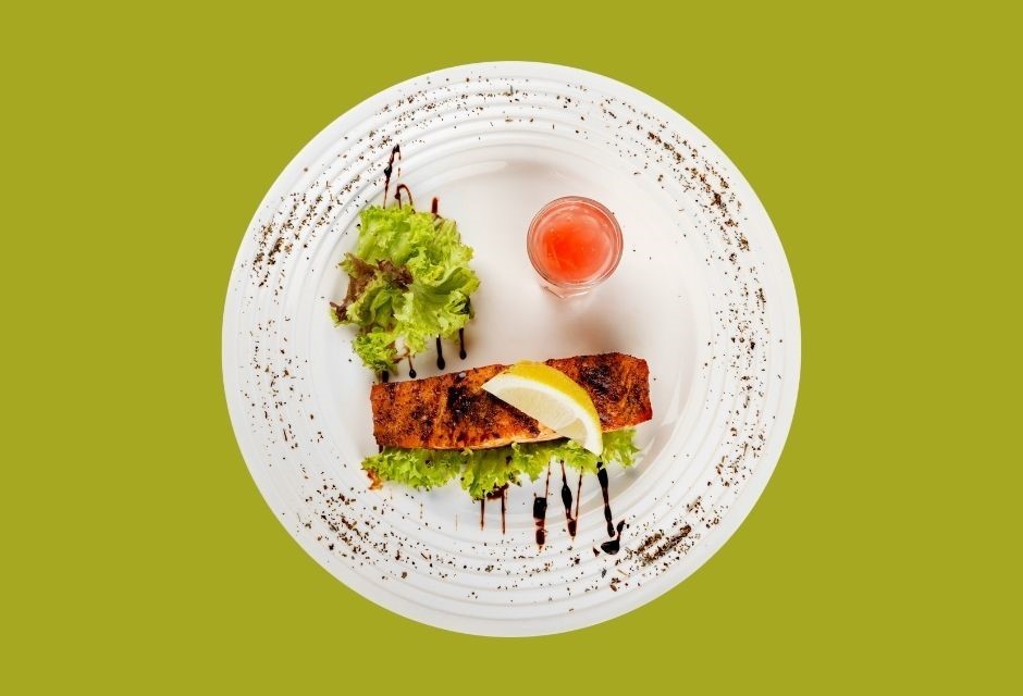 Thonon-Diät dargestellt von Lachsfilet mit etwas Salatblättern auf einem Teller dekoriert