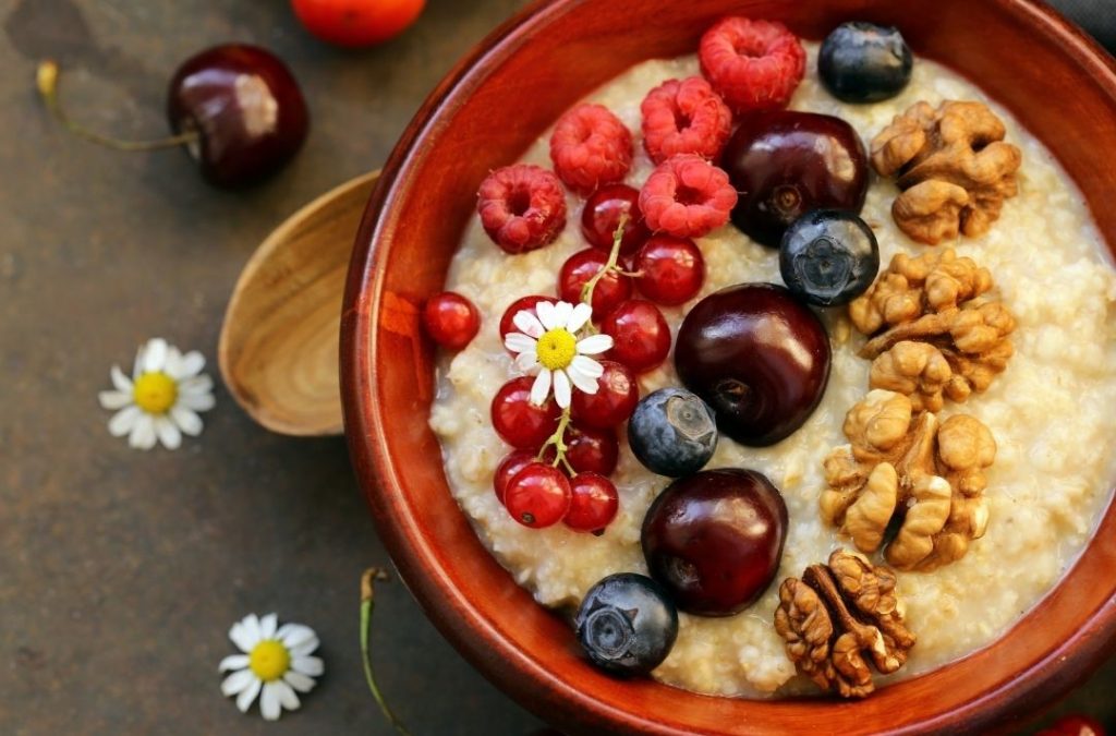 Abnehmen mit Haferflocken dargestellt von Porridge mit Nüssen und Beeren